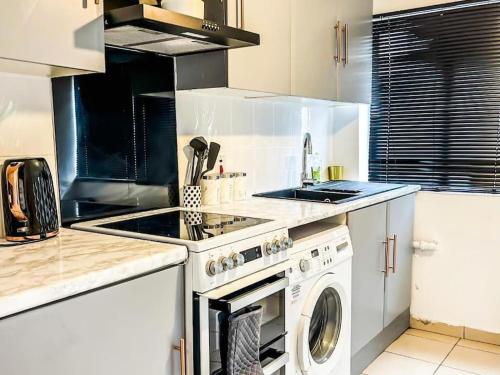 ShirleySpacious home with free parking的厨房配有炉灶和洗衣机。
