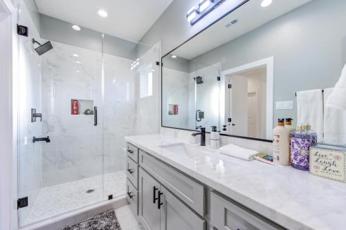 休斯顿Spacious 4-Bedroom Family Home Houston, TX的带淋浴和盥洗盆的白色浴室