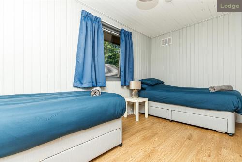 基林Firbush Lochside Lodges的一间卧室设有两张床和窗户。