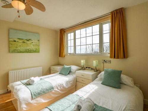 斯凯格内斯Martell Cottage的带2扇窗户的客房内的2张床
