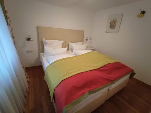 福尔巴赫Room in Guest room - Pension Forelle - Suite的一张床上有五颜六色的毯子,放在房间里