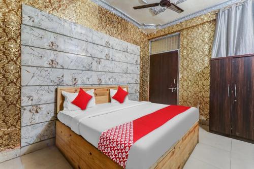 ChinhatFlagship Hotel Sai Palace Near Gomti Riverfront Park的一间卧室配有红色枕头的床