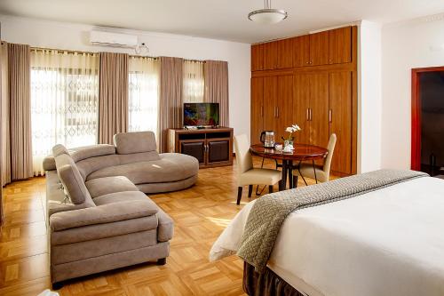 MatolaPlatinum Lodge的一间卧室配有一张床、一张沙发和一张桌子