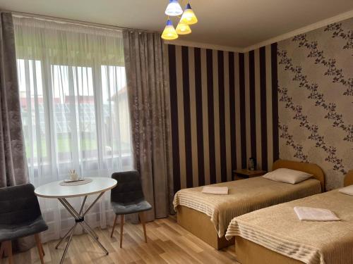 ChynadiyovoMini-Hotel "Nord"的客房设有两张床、一张桌子和一扇窗户。