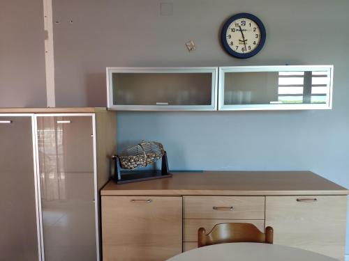 皮内托Homiday - Residence Prestige的厨房配有柜台和墙上的时钟
