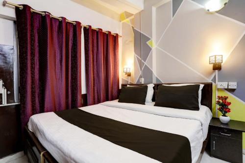 新德里Hotel Raaz Luxury Near Delhi Airport的配有红色窗帘的客房内的两张床