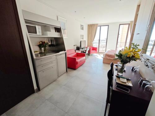 卡西斯Cassis Loc - Chambre Meublée的厨房以及带红色沙发的起居室。