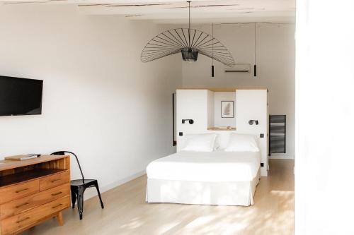 圣马迪拉莫Mas de la Fouque - Hôtel & Spa的一间白色卧室,配有床和电视