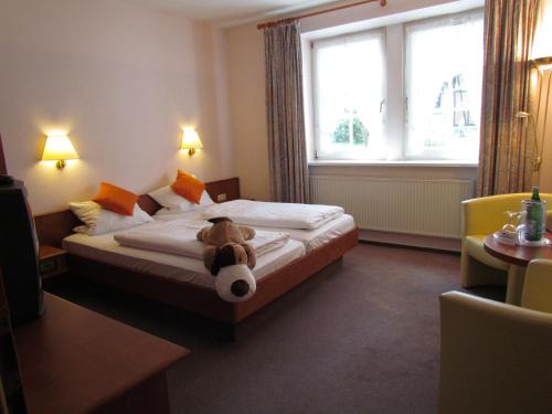 Suhlendorf布鲁恩霍夫度假酒店的坐在酒店房间床上的泰迪熊