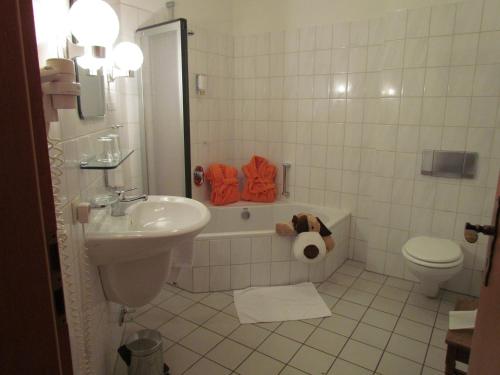 Suhlendorf布鲁恩霍夫度假酒店的浴室配有卫生间、浴缸和水槽。