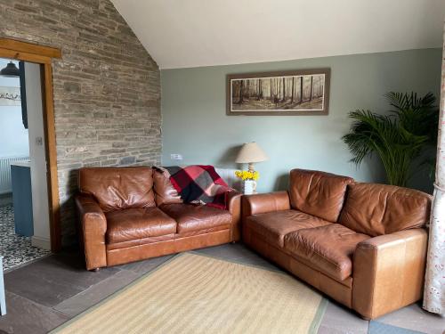 赫里福德Luxury, Spacious Cottage in the Black Mountains的客厅配有2张棕色皮沙发