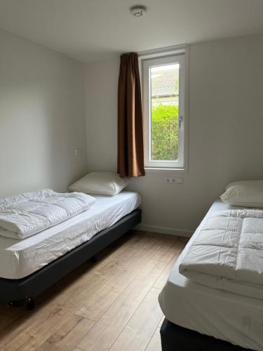 东卡佩勒Luxe lodges met airco的带窗户的客房内的两张床