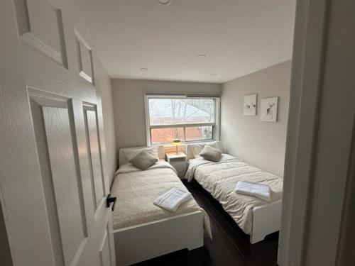 米西索加Enjoy luxury living的小房间设有两张床和窗户