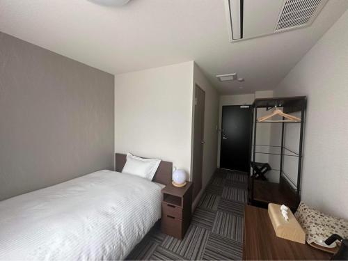 川口市WORLD ASAHI HOTEL的一间小卧室,配有一张床和一把椅子