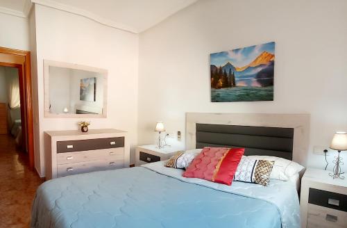 托雷维耶哈Sol, mar y arena的卧室配有一张床,墙上挂有绘画作品