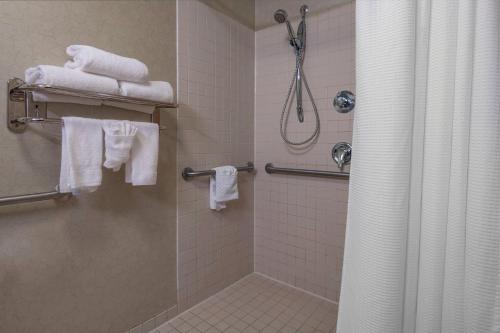 Devens德文斯通用活动中心春季山丘套房酒店的带淋浴和白色毛巾的浴室