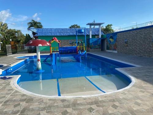 蒙特里亚hotel Vila orlanda finca hotel eventos的一个带水上公园的游泳池,并设有一个游乐场