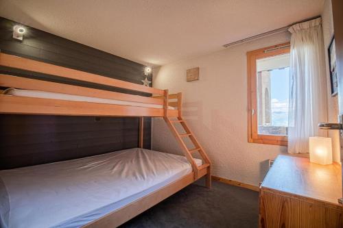 瓦尔莫雷尔PIERRAFORT G - Appartement PIERRAFORT 19 pour 5 Personnes 20的一间卧室设有两张双层床和一扇窗户。