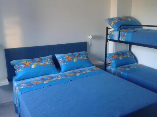 卡斯特里尼亚诺德尔卡波Wohnung in Marina Di Felloniche mit Kleinem Garten的一间卧室配有蓝色的床和一张双层床。