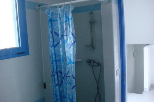 卡斯特里尼亚诺德尔卡波Wohnung in Marina Di Felloniche mit Kleinem Garten的浴室内配有蓝色淋浴帘