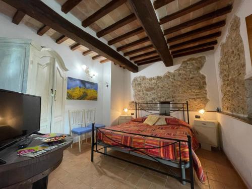 马萨马尔塔纳La Casa di Gelsomino的一间卧室配有一张床,并在一间客房内配有电视。