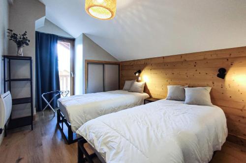 瓦尔莫雷尔CHALET LUMI - Chalet CHALET MAGDALENA pour 6 Personnes 624的一间卧室设有两张床和大窗户