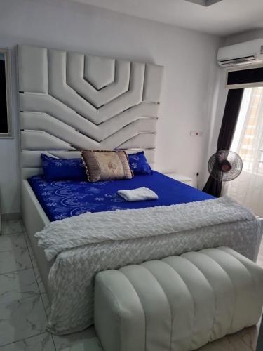 拉各斯Pentagon Court Phase 1 Apartment Ikota的一间卧室配有一张带白色床头板的床