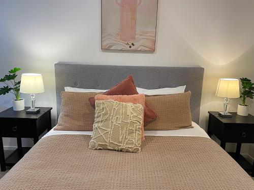 奥克兰布什假期住宿公寓的一间卧室配有一张带枕头的床和两盏灯。