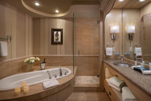 基洛纳The Royal Kelowna - Bellstar Hotels & Resorts的带浴缸和盥洗盆的大浴室