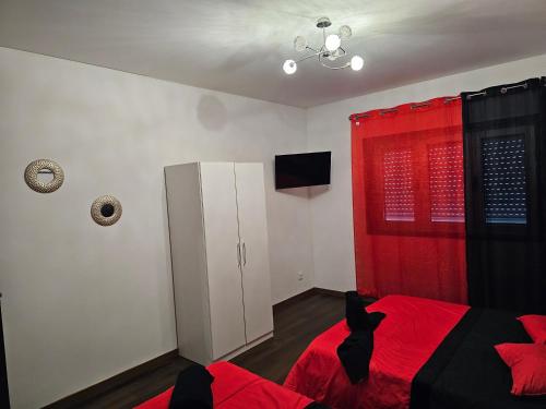 里奥廷托雷斯公寓的一间卧室配有红色的床和红色窗帘