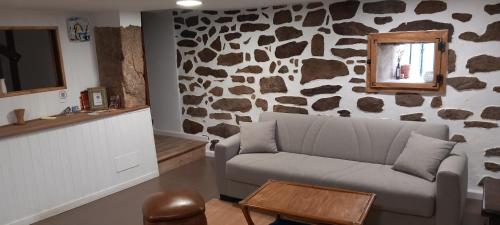 AmésCasa da Eiriña的带沙发和岩石墙的客厅