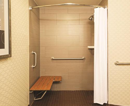 奥斯汀DoubleTree Suites by Hilton Hotel Austin的浴室设有木制长凳和淋浴
