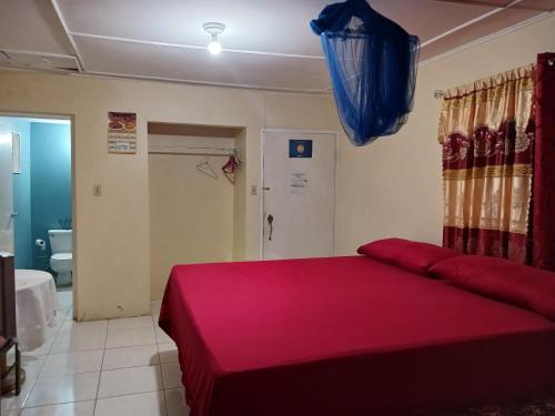 欧丘里欧蒂娜旅馆的一间卧室配有一张带红色毯子的大床
