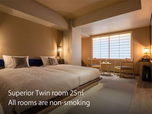 京都京都河原町三条瑞索酒店的一间卧室配有一张床、一张桌子和一个窗户。