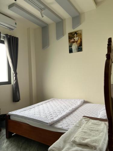 波来古市SAIGON - PLEIKU HOTEL的卧室配有一张床,墙上挂着一幅画