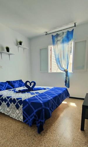 马斯帕洛马斯Sunny Room in Habitat的白色客房的一张蓝色床,设有窗户
