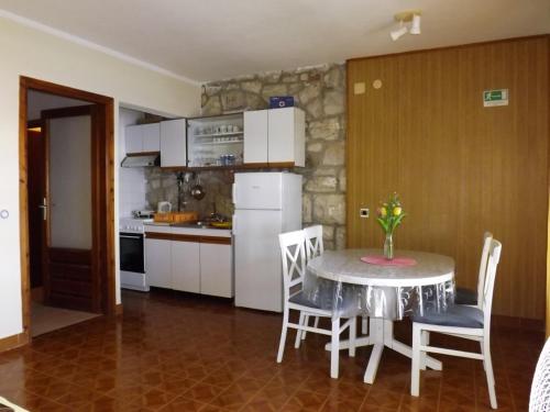 普利兹巴Apartments by the sea Prizba, Korcula - 4483的厨房配有桌椅和冰箱。