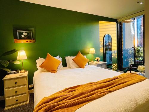 墨尔本Extraordinary holiday stay for Melbourne explore的一间卧室设有一张大床和绿色的墙壁