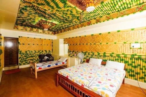 蓬蒂切里Sejour D Confort (Bamboo Stays)的一间卧室设有两张床和壁画墙