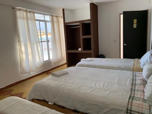 帕拉伊索HOTEL PUERTO REAL SUITES的一间卧室设有两张床和窗户。