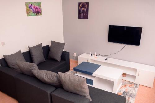 埃尔多雷特Unity homes #G08的客厅配有黑色沙发和电视