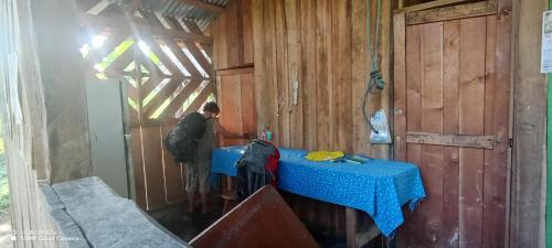SoposoLodging and adventures的站在一个配有蓝色桌子的小屋里的人