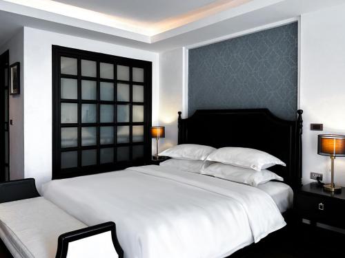 清迈Glory Boutique Suites 清迈古城荣耀精品酒店的卧室设有一张白色大床和一扇窗户。