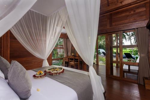 乌布Berlima Wooden Lodge by Pramana Villas的卧室配有白色窗帘的床