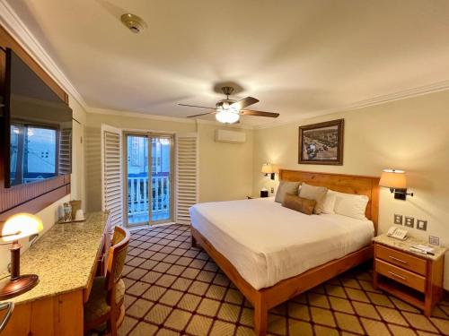 提华纳凯撒酒店的一间卧室配有一张床、一张书桌和一台电视