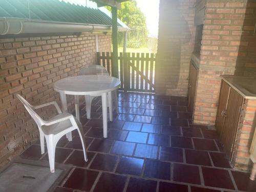 XuíParada y relax en Alvorada, Barra do Chui的砖砌庭院里的白色桌子和椅子