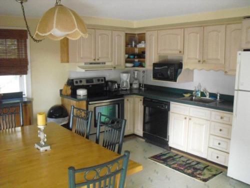 Barnegat LightAmazing Apartment In Barnegat Light With 3 Bedrooms, Internet And Wifi的带餐桌的厨房和带白色橱柜的厨房