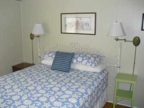 Barnegat LightAmazing Apartment In Barnegat Light With 3 Bedrooms, Internet And Wifi的一间卧室配有一张带两盏灯的蓝色和白色的床。