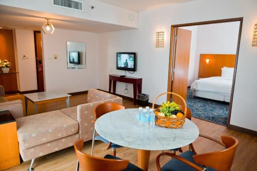 民都鲁民都鲁园市艾佛利酒店的酒店客房设有桌子和客厅。