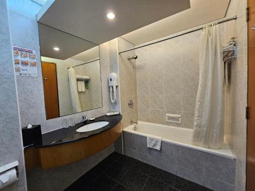 民都鲁民都鲁园市艾佛利酒店的一间带水槽、浴缸和淋浴的浴室